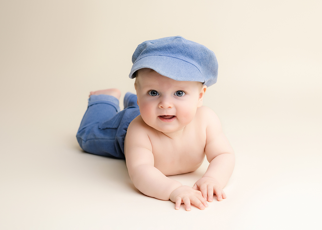 baby fotoshoot Rotterdam baby ligt op buik en kijkt in camera