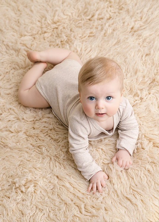 baby fotoshoot Rotterdam baby ligt op buik en kijkt in camera