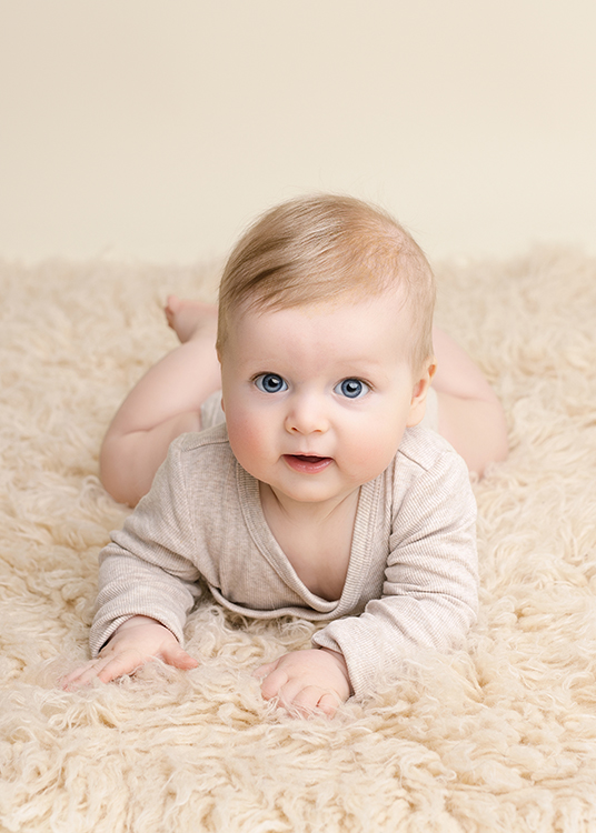 baby fotoshoot Rotterdam baby ligt op buik en kijkt in camera