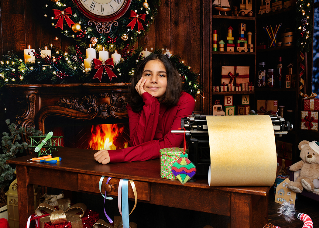 kerst kerstshoot rotterdam christmas photoshoot fotograaf sachin fotografie familie mama (2) jongen op de foto in de werkkamer van de kerstman en de kerstvrouw tijdens een fotoshoot bij Sachin Fotografie in Rotterdam
