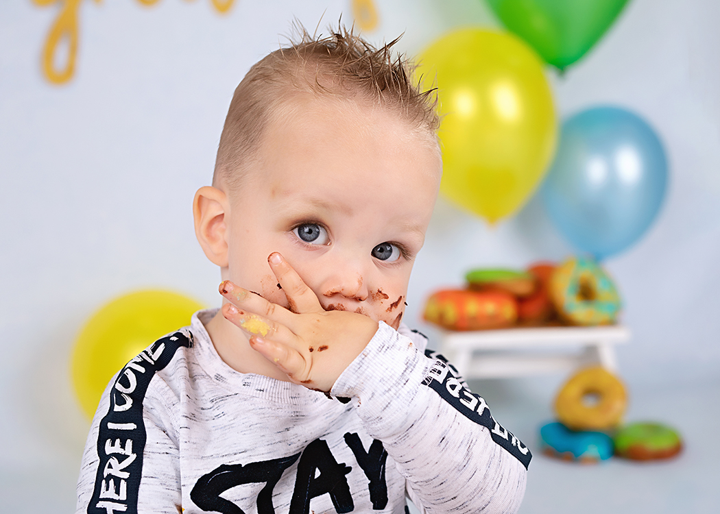 jongen eet donut van zijn vingers fotoshoot