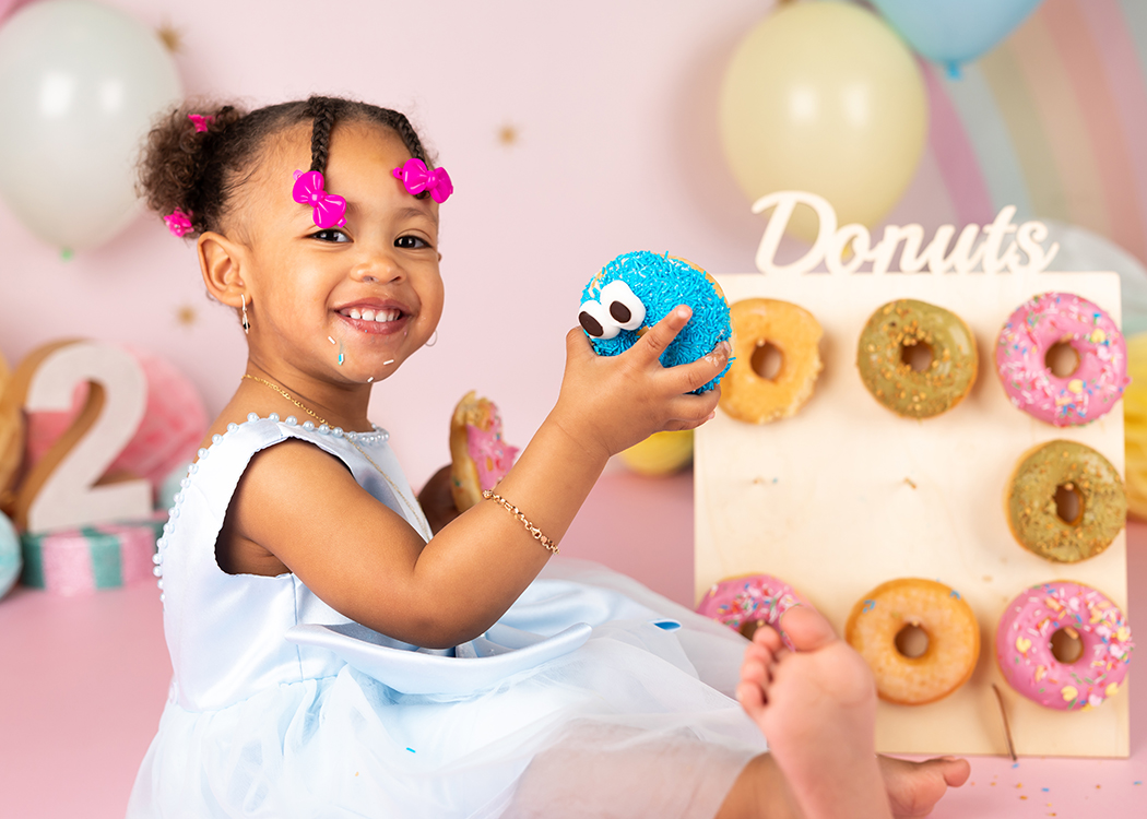 meisje lacht met donuts tijdens fotoshoot